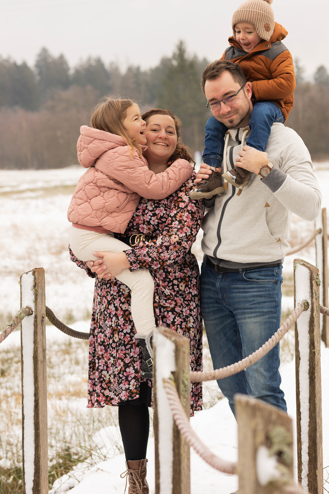 Fotografin für Familie zeigt Kinder auf dem Arm von Eltern