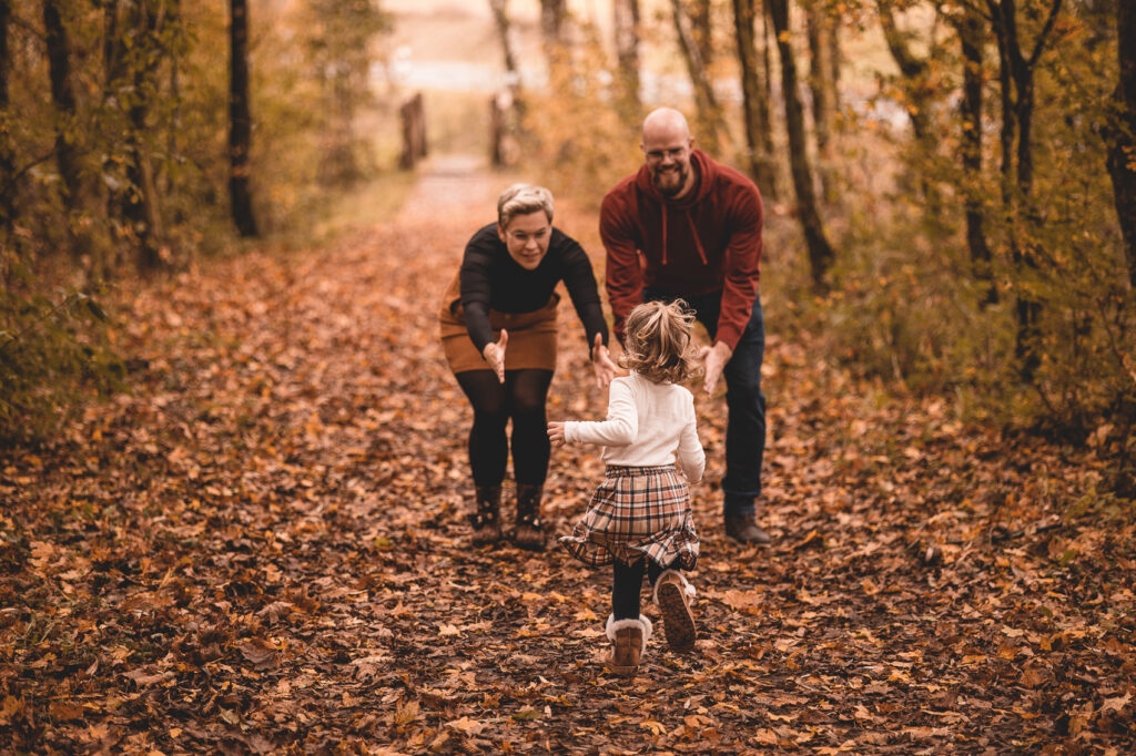 Familie im Wald, Kind läuft auf Eltern zu